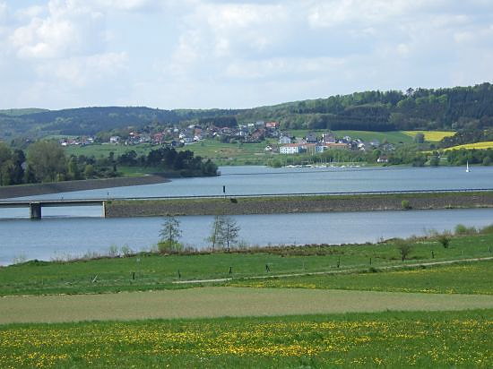Landschaft am Aartalsee mit Wasser, Feldern, Wäldern und Ortschaft